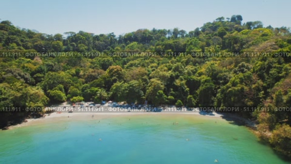 Secluded tropical beach with people swimming and relaxing near sea water. Стоковое видео, видеограф Ольга Сухарева / Фотобанк Лори