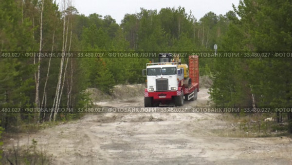 Седельный тягач Kenworth C500K перевозит экскаватор. A Kenworth C500K tractor truck carries an excavator. (2020 год). Редакционное видео, видеограф Евгений Романов / Фотобанк Лори