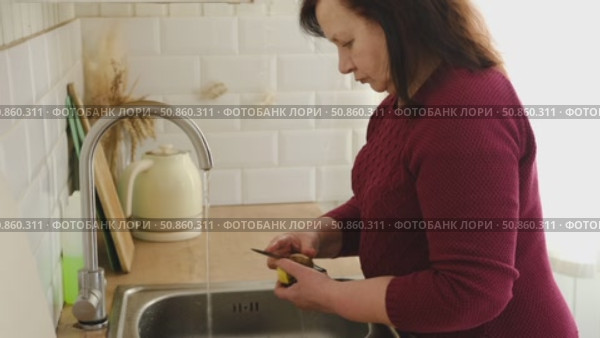Senior active woman cooking lunch at home in modern kitchen. Healthy eating, food and culinary concept. Hands of old lady with knife chopping vegetables, grating carrots. Elderly female cook a soup. Стоковое видео, видеограф Марина Демидюк / Фотобанк Лори
