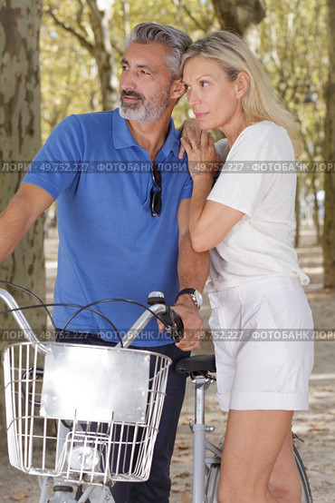senior couple looking at something while biking outdoors. Стоковое фото, агентство Ingram Publishing / Фотобанк Лори