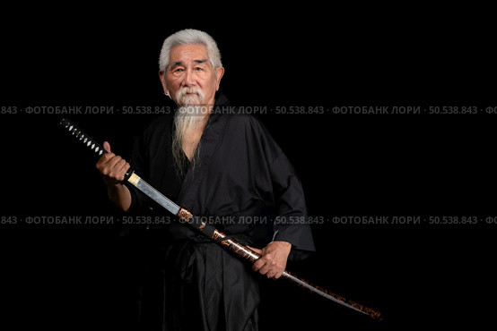 Senior Japanese samurai with katana sword on black background, studio shot. Стоковое фото, агентство Ingram Publishing / Фотобанк Лори