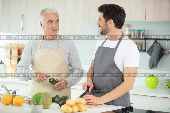 senior man with beard preparing dinner with son. Стоковое фото, агентство Ingram Publishing / Фотобанк Лори