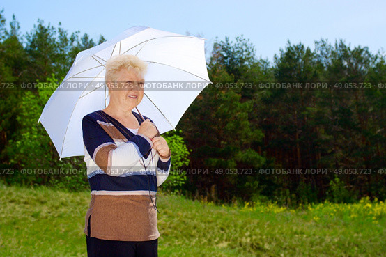Senior woman with parasol in forest. Стоковое фото, агентство Ingram Publishing / Фотобанк Лори