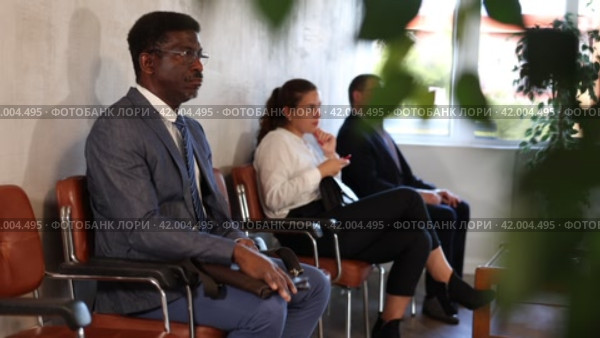 Serious-minded African male candidate siting on chair and waiting for job interview in hallway. Стоковое видео, видеограф Яков Филимонов / Фотобанк Лори