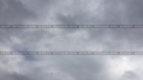 Серые облака быстро движутся по небу. Все небо покрыто серо-голубыми кучевыми облаками, из которых в любой момент может пойти дождь. Облака движутся быстро, меняя форму и размер. Стоковое видео, видеограф Andrew_Swarga / Фотобанк Лори