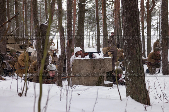 Sestroretsk, Russia - February 19, 2023: In a winter scene, soldiers plan for a key moment in WWII, surrounded by snow and trees in a historical reenactment. Редакционное фото, фотограф Aleksandr Golubev / Фотобанк Лори