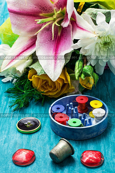 sewing accessories with a bouquet of fresh flowers on turquoise background. Стоковое фото, агентство Ingram Publishing / Фотобанк Лори
