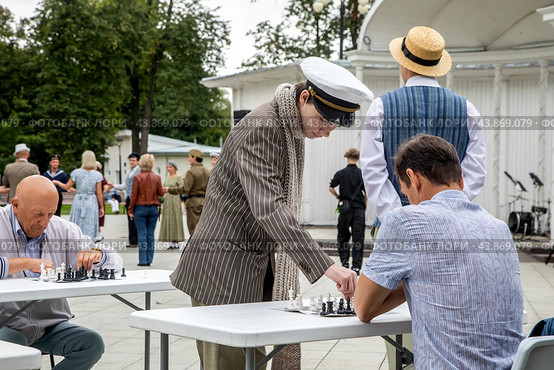 Шахматист в образе Остапа Бендера принимает участие в сеансе одновременной игры в шахматы в парке Останкино города Москвы во время празднования Дня рождения выставки ВДНХ, Россия (2024 год). Редакционное фото, фотограф Николай Винокуров / Фотобанк Лори