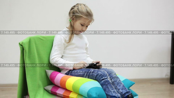 Шестилетний ребенок играет в игры на смартфоне в комнате. Стоковое видео, видеограф Кекяляйнен Андрей / Фотобанк Лори