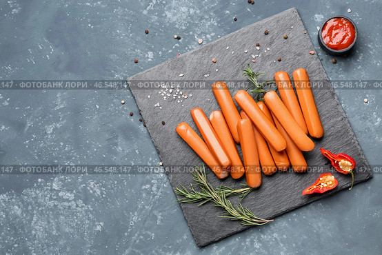 Шиферная доска с вкусными сосисками на синем фоне. Стоковое фото, фотограф Pixel_shot / Фотобанк Лори
