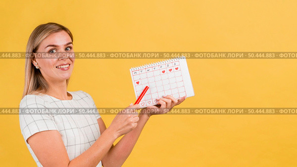 sideways woman showing her menstruation calendar. Стоковое фото, агентство Ingram Publishing / Фотобанк Лори