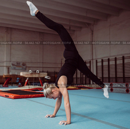 sideways young blonde woman training gymnastics championship. Стоковое фото, агентство Ingram Publishing / Фотобанк Лори