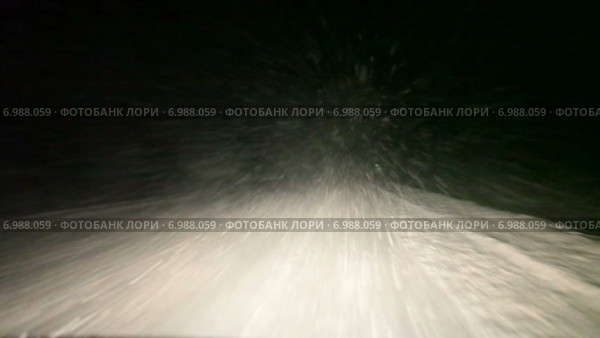 Сильный снегопад в свете фар автомобиля на ночной автодороге на севере России, Карелия. Стоковое видео, видеограф Кекяляйнен Андрей / Фотобанк Лори