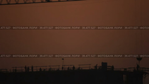 Силуэты строителей на строительной площадке в полумраке позднего вечера. Стоковое видео, видеограф Цыбин Вадим / Фотобанк Лори