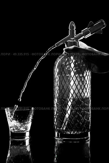 siphon with soda copulation on the table on a black background with a full glass, jet and drops. Стоковое фото, агентство Ingram Publishing / Фотобанк Лори