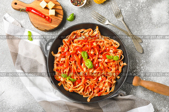 Сковорода со вкусной пастой и томатным соусом на столе. Стоковое фото, фотограф Pixel_shot / Фотобанк Лори