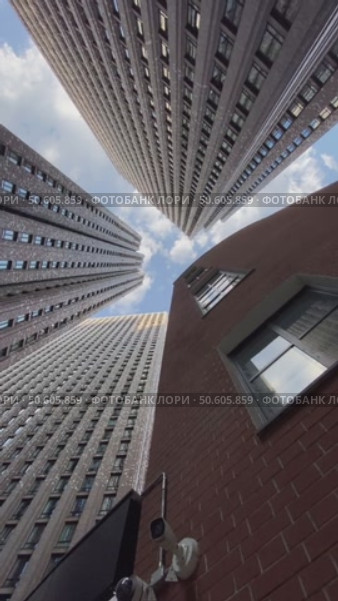 Skyscrapers from below against a blue sky, capturing an urban architectural perspective. Стоковое видео, видеограф Анастасия Золотницкая / Фотобанк Лори