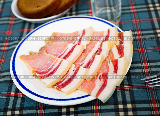 Slices of fresh sliced bacon on a plate. Стоковое фото, фотограф Яков Филимонов / Фотобанк Лори