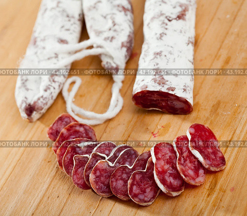 Slicing delicious Spanish smoked sausage fuete. Стоковое фото, фотограф Яков Филимонов / Фотобанк Лори