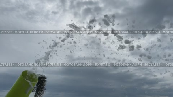 Slow motion where white foam flies out onto the playground to celebrate. Foam cannon on the background of the sky with clouds. Стоковое видео, видеограф Darya Komarova / Фотобанк Лори