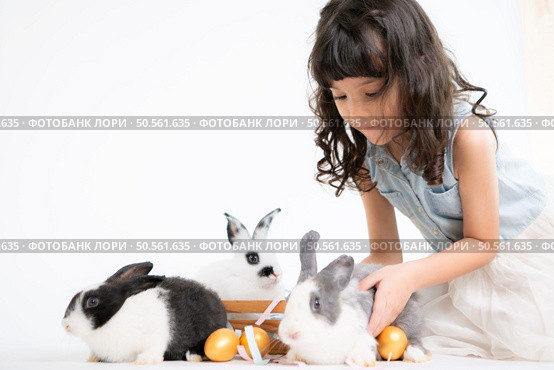 Smiling little girl and with their beloved fluffy rabbit, showcasing the beauty of friendship between humans and animals. Стоковое фото, агентство Ingram Publishing / Фотобанк Лори