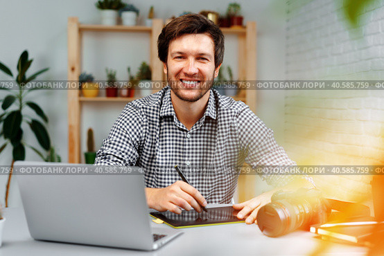Smiling man photographer or retoucher working from home. Стоковое фото, фотограф Сергей Толмачёв / Фотобанк Лори
