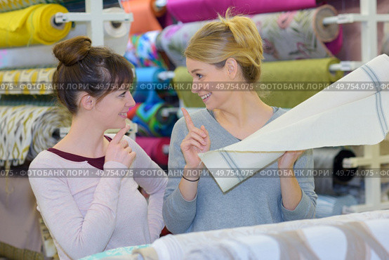 smiling young customer buying fabric. Стоковое фото, агентство Ingram Publishing / Фотобанк Лори