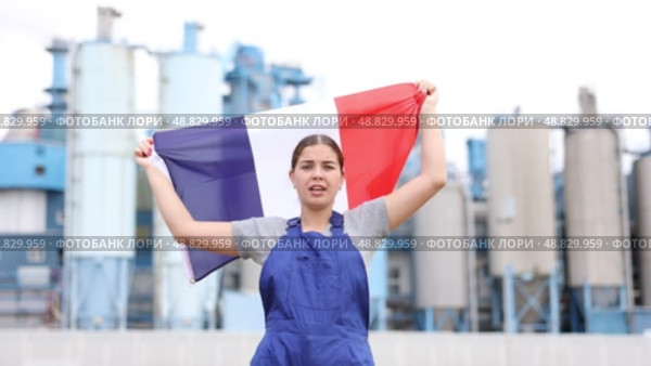 Smiling young woman worker posing with France flag in hands against background of factory. Стоковое видео, видеограф Яков Филимонов / Фотобанк Лори