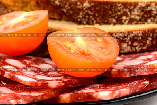 Smoked sausage, cherry tomatoes and bread on a white background. Стоковое фото, фотограф Artem Sobov / Фотобанк Лори