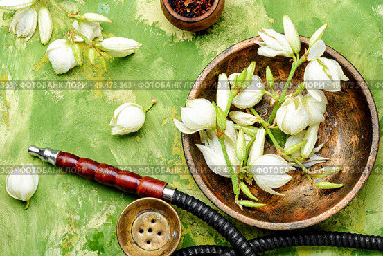 Smoking hookah with floral tobacco flavor.East kalian.Tobacco pipe and smoking tobacco with yucca flavor. Smoking pipe and floral tobacco. Стоковое фото, агентство Ingram Publishing / Фотобанк Лори