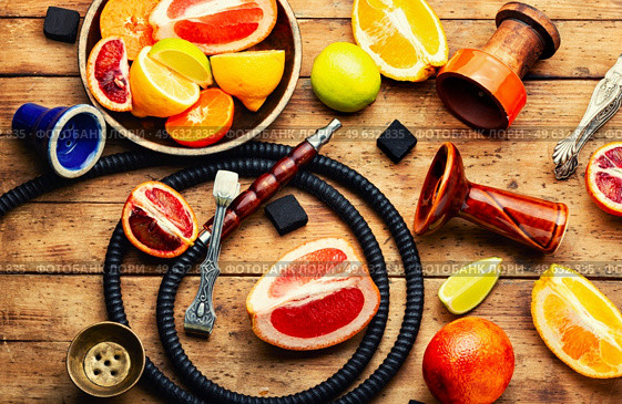Smoking kalian or shisha with tobacco from citrus fruits. Traditional oriental shisha for relaxation. Hookah with citrus tobacco. Стоковое фото, агентство Ingram Publishing / Фотобанк Лори