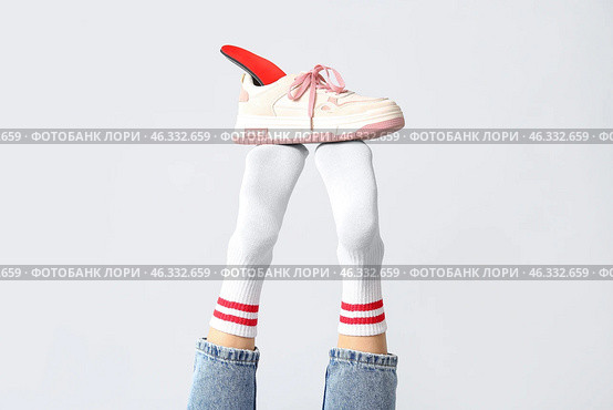 Sneakers with orthopedic insoles on female legs isolated on white background, closeup. Стоковое фото, фотограф Pixel_shot / Фотобанк Лори