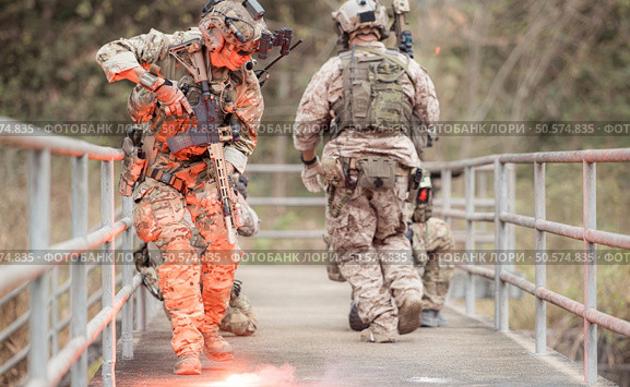 Soldiers in camouflage military uniforms carrying weapons, Reconnaissance missions in the tropical forest area, Assault infantry battle training. Стоковое фото, агентство Ingram Publishing / Фотобанк Лори