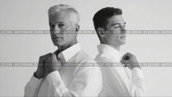 Sophisticated father son duo adjusting crisp white shirts, posing back to back against minimalist white backdrop in monochrome fashion shoot. Стоковое AI-видео, аниматор Юрий Поздников / Фотобанк Лори