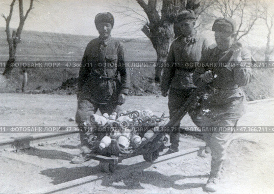 Советские солдаты в ватниках и ушанках везут груз на однорельсовой путевой тележке. Стоковое фото, фотограф Retro / Фотобанк Лори