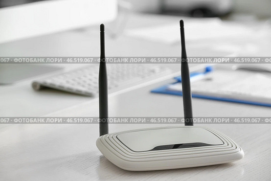 Современный wi-fi роутер на столе в офисе. Стоковое фото, фотограф Pixel_shot / Фотобанк Лори