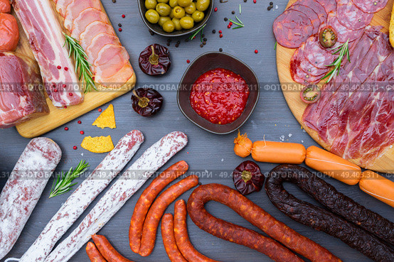 spanish tapas with pancetta, salami, chorizo, lomo, jamon with red hol salsa sause and olives, picnic table, top view. Picnic table with spanish sausage tapas. Стоковое фото, агентство Ingram Publishing / Фотобанк Лори