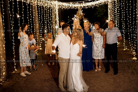sparklers at the wedding of the newlyweds in the hands of joyful guests. Редакционное фото, агентство Ingram Publishing / Фотобанк Лори
