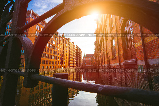 Speicherstadt Hamburg. Famous landmark of old buildings made with red bricks. Bridge and sun rays in low angle view (2018 год). Стоковое фото, фотограф Igor Tichonow / Фотобанк Лори