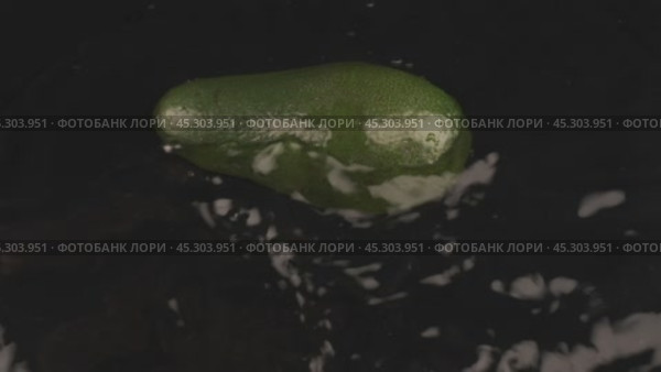 Спелый, сочный ломтик авокадо падает на черную поверхность, покрытую водой. Замедленная съемка. Падение фруктов в воду и красивые брызги воды. На фоне продуктового магазина. Стоковое видео, видеограф Александр Собко / Фотобанк Лори