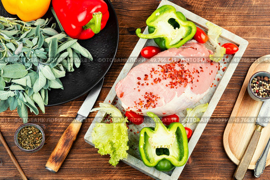 Spices on sliced raw pork meat, assorted raw meats for barbecuing on rustic wooden table.. A photo of raw pork on the table. Стоковое фото, агентство Ingram Publishing / Фотобанк Лори