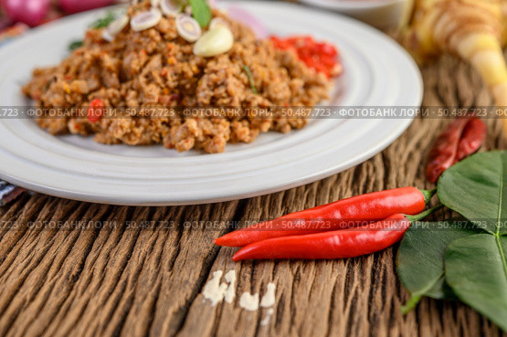 Spicy Minced Pork Salad on a white plate with red onion, lemon grass, garlic, yardlong beans, kaffir lime leaves, and spring onion. Стоковое фото, агентство Ingram Publishing / Фотобанк Лори