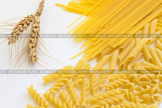 Spikelets of wheat and several types of pasta on a white background. Стоковое фото, агентство Ingram Publishing / Фотобанк Лори