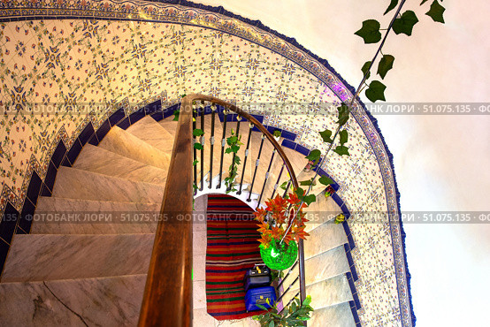 Spiral staircase. Top view. Chandelier and ceramic tiles on the wall. Стоковое фото, фотограф Евгений Ткачёв / Фотобанк Лори
