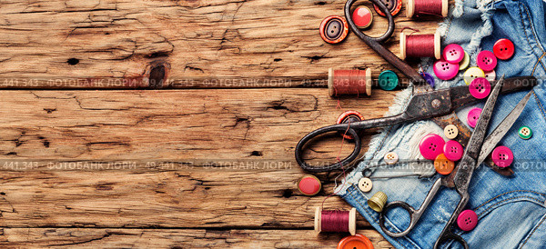 Spools of thread and basic sewing tools on wooden tabletop. Set of tailoring accessories. Стоковое фото, агентство Ingram Publishing / Фотобанк Лори