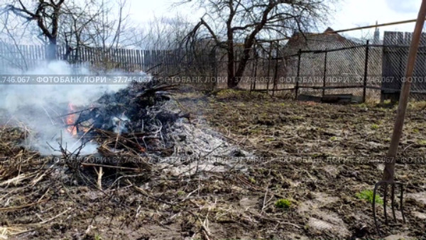 Spring garbage collection. Burning garbage in a summer cottage. Gardening work in the spring. Стоковое видео, видеограф Лилия Фролова / Фотобанк Лори