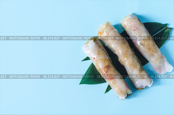 Спринг-роллы, фаршированными морепродуктами и овощами, на зеленом листе. Стоковое фото, фотограф Лозовая Людмила / Фотобанк Лори