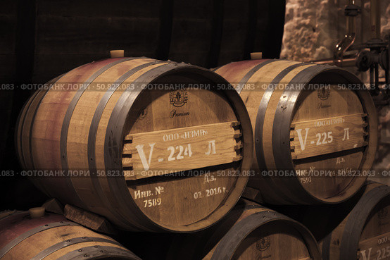 Stacked oak barrels with wine, Inkerman winery interior (2018 год). Редакционное фото, фотограф EugeneSergeev / Фотобанк Лори