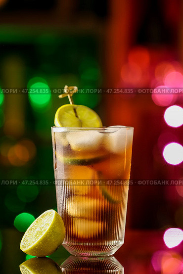 Стакан вкусного коктейля Cuba Libre на столе на фоне размытого света. Стоковое фото, фотограф Pixel_shot / Фотобанк Лори