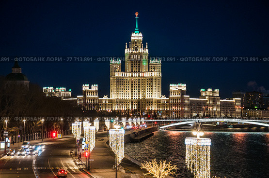 Сталинский небоскреб на Котельнической набережной Москвы-реки вечером и праздничная иллюминация на Москворецкой набережной (2018 год). Редакционное фото, фотограф Алёшина Оксана / Фотобанк Лори